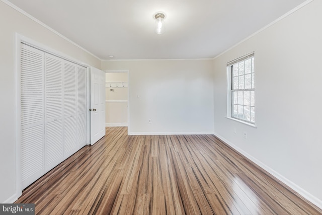 unfurnished bedroom with a closet, wood-type flooring, and ornamental molding