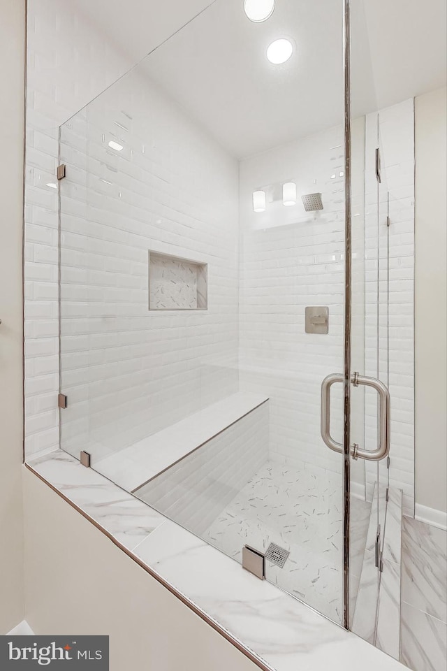 bathroom with a shower with door