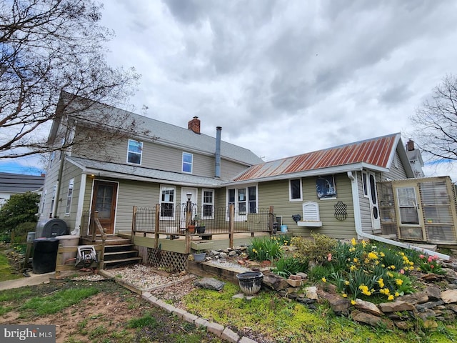 rear view of property featuring a deck