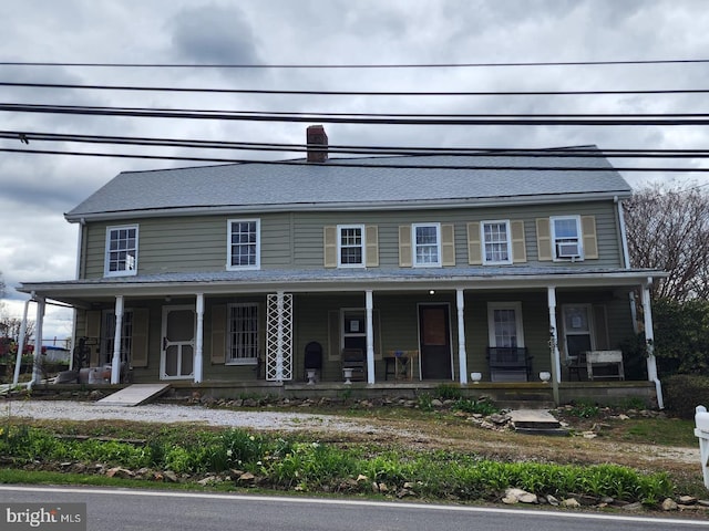 view of front of property featuring cooling unit and a porch