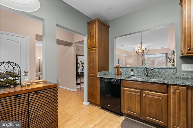 kitchen featuring dishwasher, light stone countertops, sink, and light hardwood / wood-style flooring