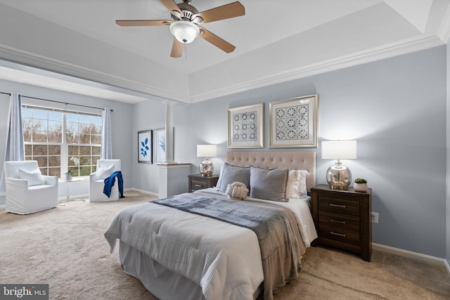 carpeted bedroom with ceiling fan, a raised ceiling, and decorative columns