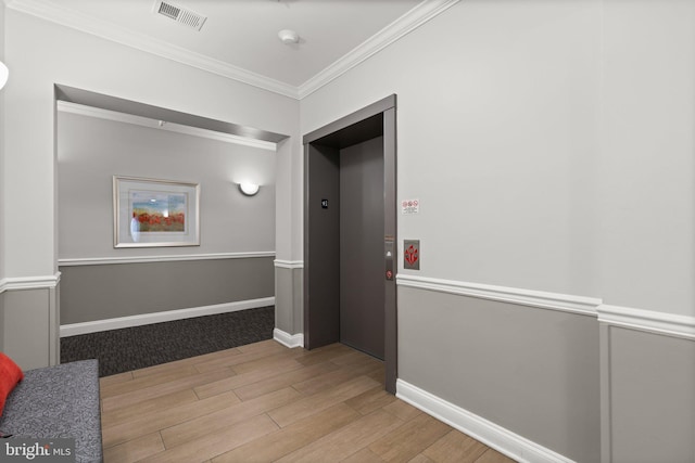 hallway with ornamental molding, elevator, and light hardwood / wood-style floors