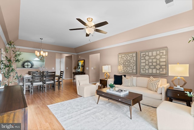 living room featuring ceiling fan with notable chandelier and wood-type flooring