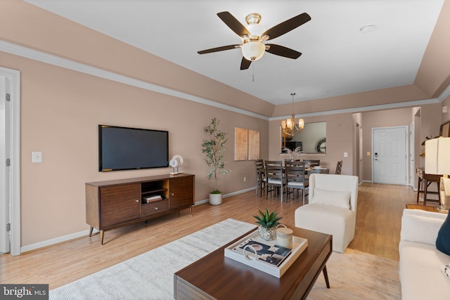 living room featuring ornamental molding, ceiling fan with notable chandelier, and light wood-type flooring