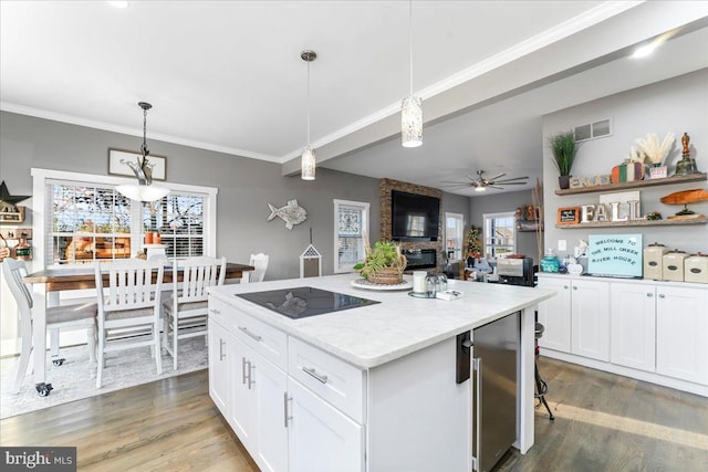 kitchen with dark wood-type flooring, white cabinetry, hanging light fixtures, and beverage cooler