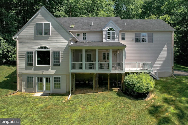 rear view of property featuring a yard and a deck