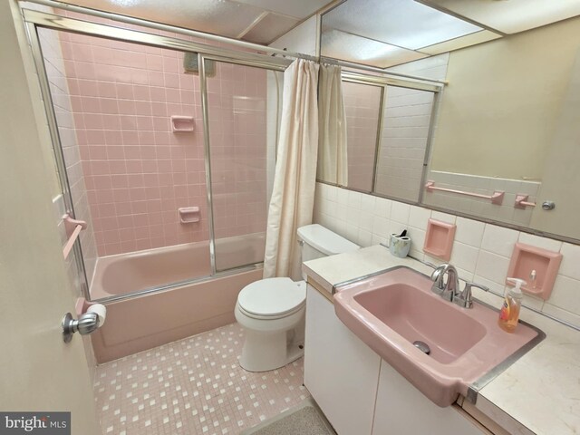 full bathroom featuring tile patterned flooring, backsplash, toilet, and tile walls