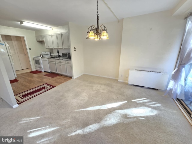 interior space with radiator heating unit, hanging light fixtures, light hardwood / wood-style flooring, a chandelier, and white appliances