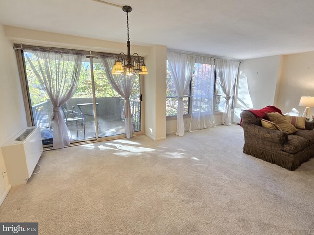 carpeted living room featuring a chandelier