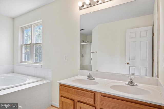 bathroom with vanity and independent shower and bath