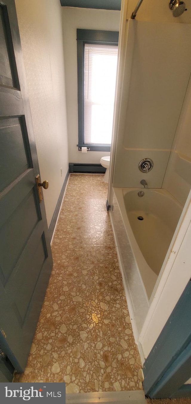 bathroom with bathtub / shower combination, toilet, and a baseboard heating unit