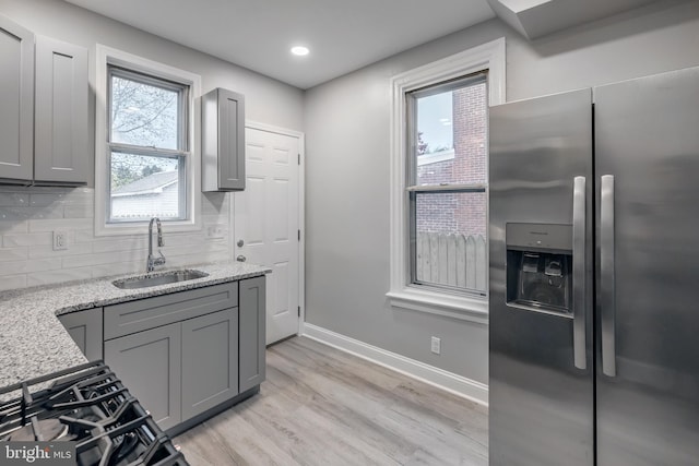 kitchen featuring stainless steel refrigerator with ice dispenser, gray cabinets, and sink