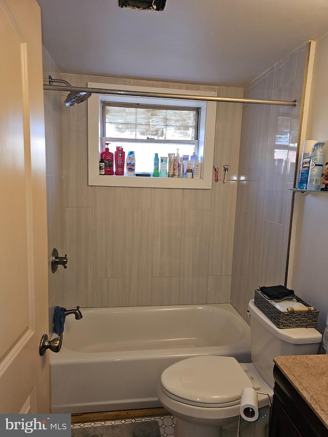 full bathroom featuring vanity, tiled shower / bath combo, and toilet