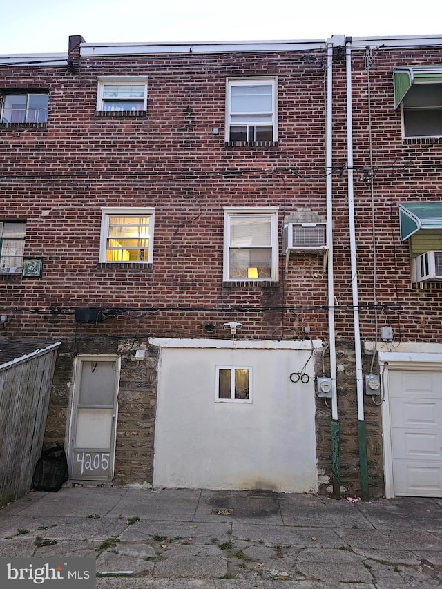 back of property featuring an AC wall unit