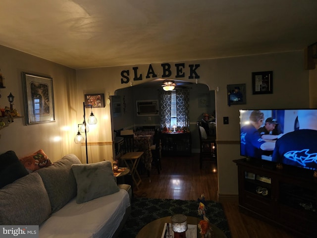 living room with a wall mounted air conditioner and dark hardwood / wood-style flooring