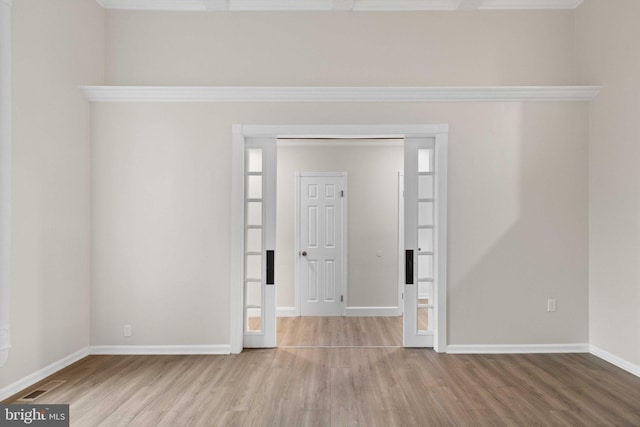 spare room with light hardwood / wood-style flooring and crown molding