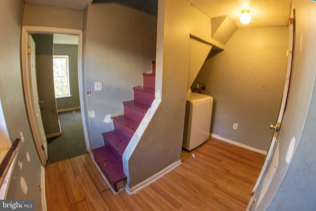 stairway featuring wood-type flooring and washer / dryer