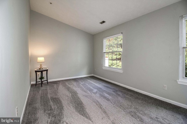 carpeted spare room featuring lofted ceiling