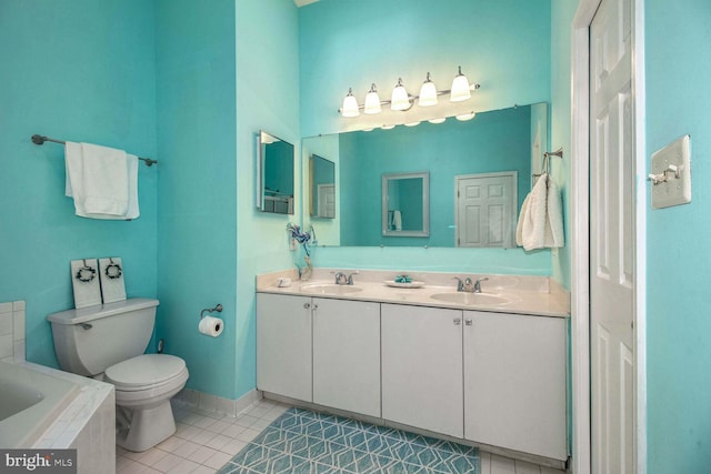 bathroom featuring tile patterned flooring, vanity, a relaxing tiled tub, and toilet