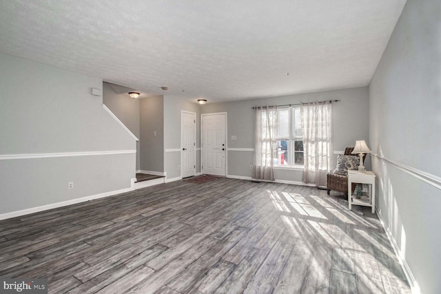 unfurnished living room with hardwood / wood-style flooring and a textured ceiling