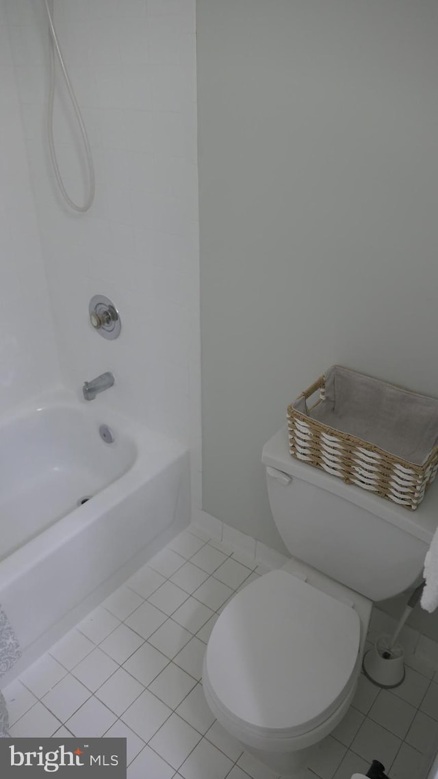 bathroom featuring tile patterned flooring, toilet, and bathing tub / shower combination