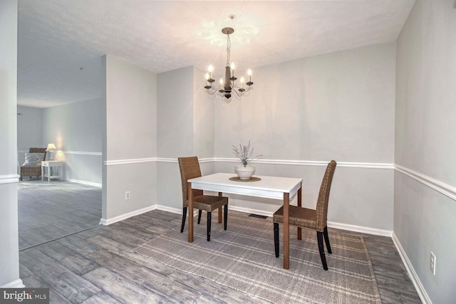 dining room with a chandelier, a textured ceiling, and dark wood-type flooring