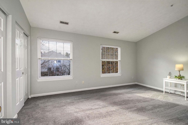 spare room with dark carpet