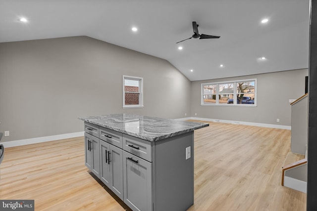 kitchen with gray cabinetry, ceiling fan, a center island, lofted ceiling, and light wood-type flooring