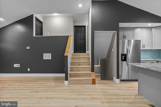 staircase featuring hardwood / wood-style floors and vaulted ceiling