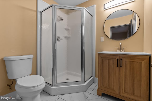 bathroom with vanity, toilet, and a shower with door