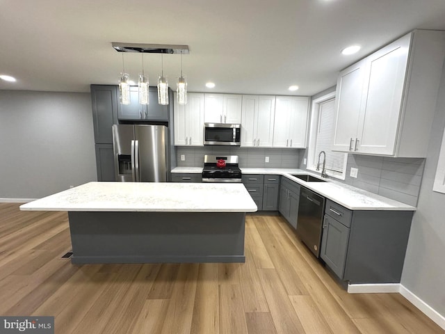 kitchen featuring sink, stainless steel appliances, light hardwood / wood-style floors, gray cabinets, and white cabinets