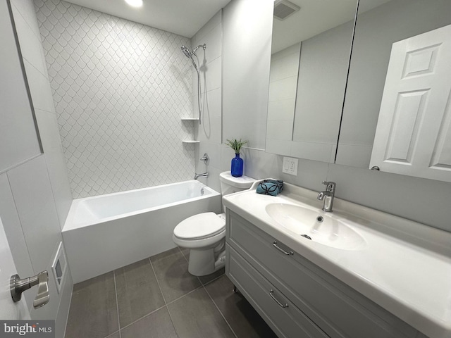 full bathroom featuring tile patterned flooring, vanity, toilet, and tiled shower / bath