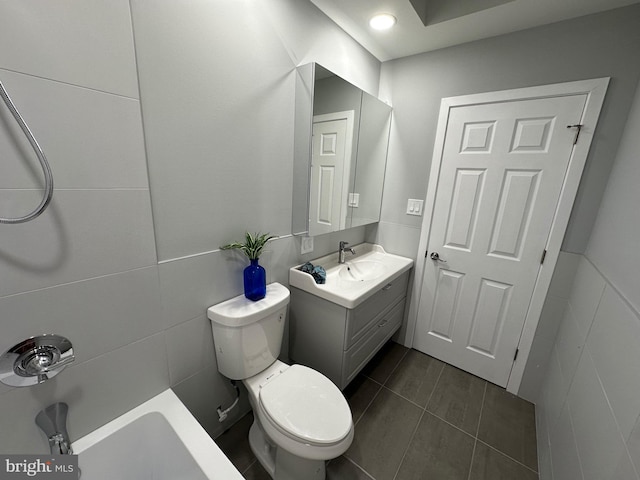 bathroom with tile patterned flooring, vanity, toilet, and tile walls