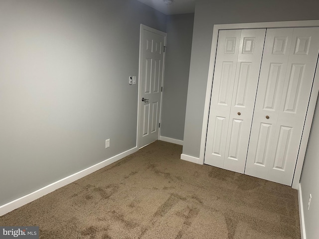 unfurnished bedroom with carpet floors and a closet