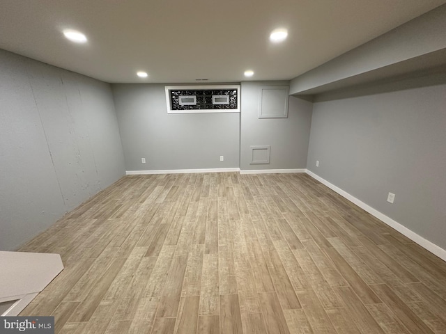 basement with light hardwood / wood-style flooring