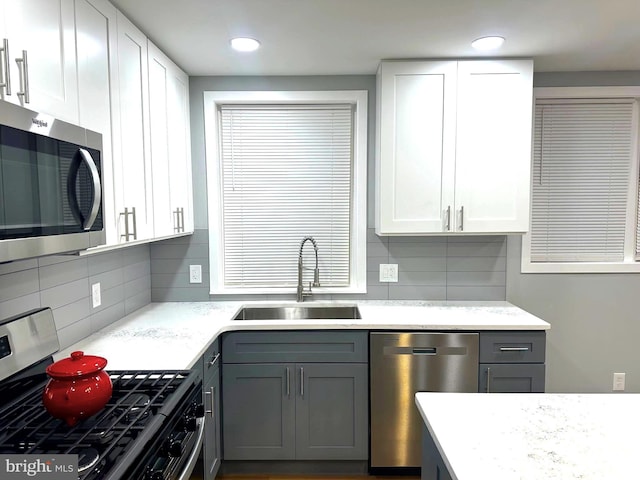 kitchen with gray cabinets, white cabinetry, sink, and appliances with stainless steel finishes