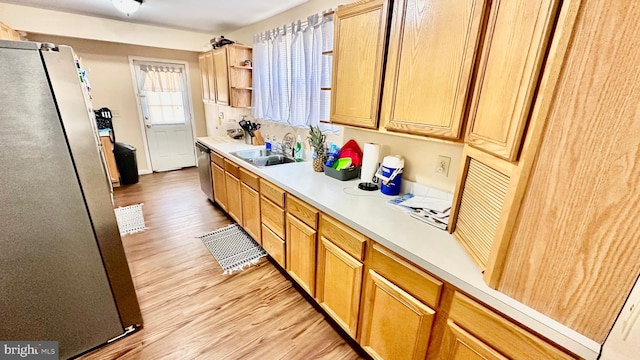 kitchen with stainless steel appliances, light hardwood / wood-style flooring, and sink