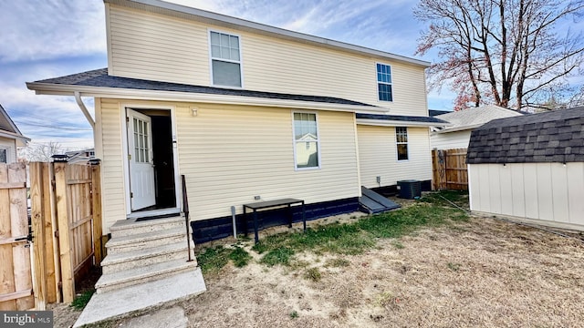 rear view of house featuring a shed and central air condition unit