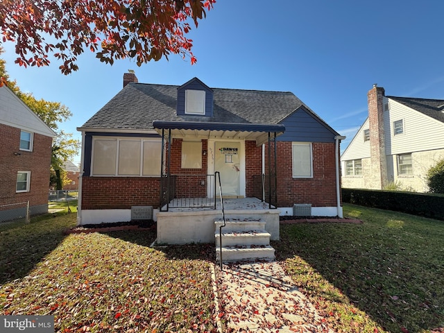 bungalow with a front yard and covered porch