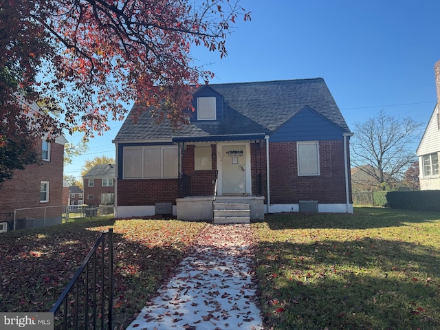 view of front of property with central AC and a front yard