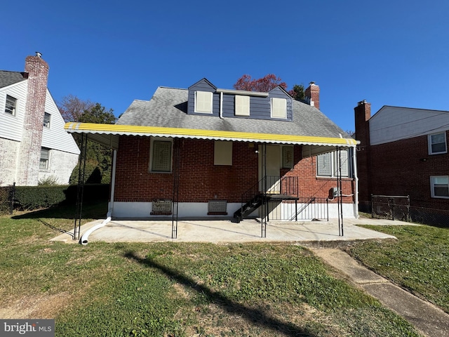 rear view of property featuring a lawn