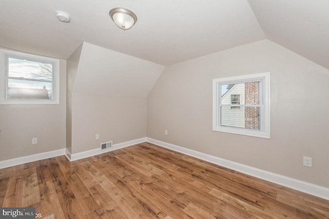 additional living space featuring lofted ceiling and wood-type flooring