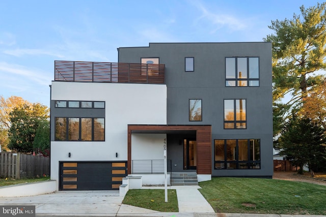 contemporary house with a garage, a balcony, and a front yard