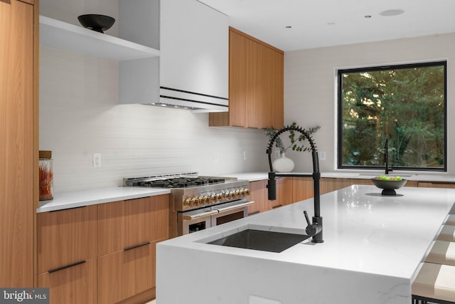 kitchen featuring light stone countertops, high end stainless steel range oven, and tasteful backsplash