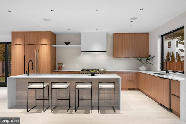 kitchen with sink, a kitchen island with sink, a breakfast bar area, and tasteful backsplash