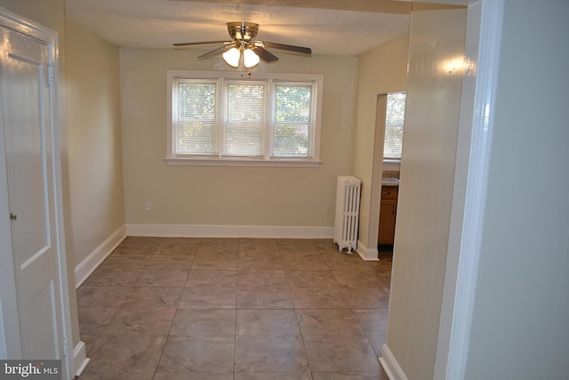 unfurnished room with ceiling fan, light tile patterned floors, a textured ceiling, and radiator