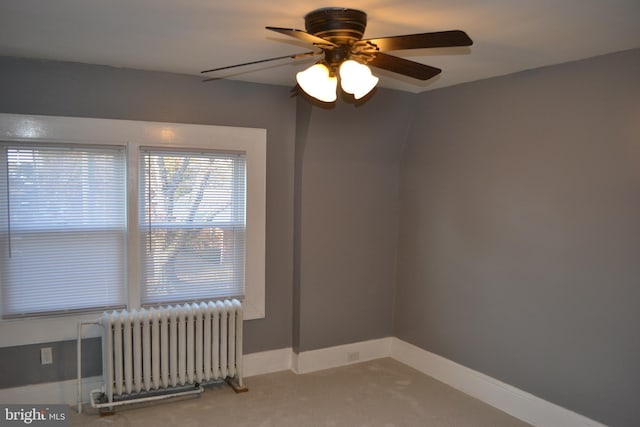 empty room with ceiling fan and radiator heating unit