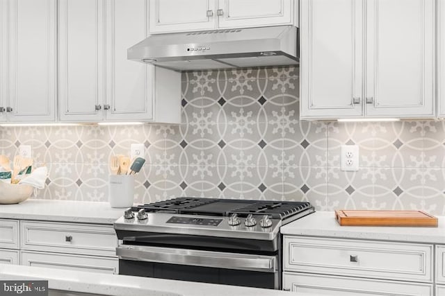 kitchen with gas range, ventilation hood, white cabinetry, and tasteful backsplash