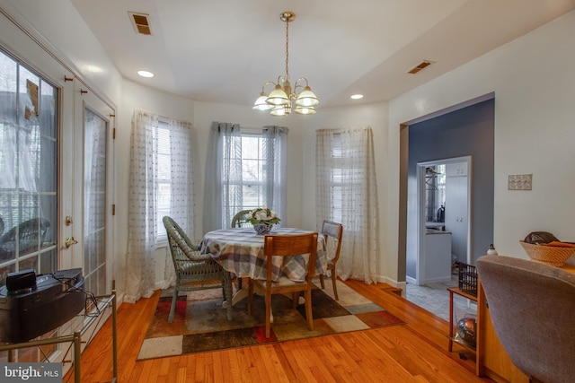 dining space featuring an inviting chandelier and light hardwood / wood-style flooring